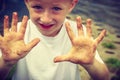 Child playing outdoor showing dirty muddy hands. Royalty Free Stock Photo