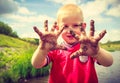 Child playing outdoor showing dirty muddy hands. Royalty Free Stock Photo