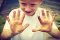 Child playing outdoor showing dirty muddy hands. Royalty Free Stock Photo