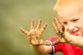 Child playing outdoor showing dirty muddy hands. Royalty Free Stock Photo