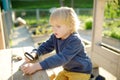 Child playing with pebbles and explores them with a magnifying glass. Little boy studying of various natural materials. Kids