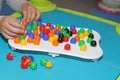 Child playing plastic colored toy mosaic on the table Royalty Free Stock Photo