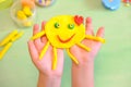 Child playing with plasticine, colorful modeling clay and sculpting funny sun . Home Education game with clay. Early development