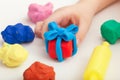 Child playing with playdough and making a giftbox