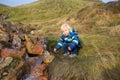 Child playing on a pond in geothermal area in Krysuvik on early sunny morning, Southern Peninsula Reykjanesskagi, Reykjanes