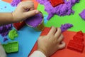 Child playing with purple kinetic sand