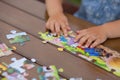 Child playing with puzzle. Child`s hands closeup