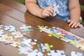 Child playing with puzzle. Child`s hands closeup