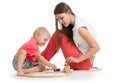 Child playing with railway toys on floor, isolated on white. Mother helps to son Royalty Free Stock Photo