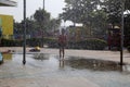 Child playing in the rain falling in the water park Royalty Free Stock Photo