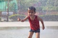 Child playing in the rain falling in the water park Royalty Free Stock Photo