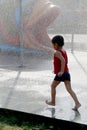 Child playing in the rain falling in the water park Royalty Free Stock Photo