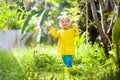 Child playing in the rain. Kid with umbrella