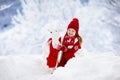 Child playing with reindeer in snow on Christmas vacation. Winter outdoor fun. Kids play in snowy park on Xmas eve. Little girl in Royalty Free Stock Photo