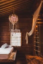 Child playing room inside wooden house with swing, bed and hanging ladder