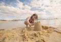 pretty little girl making sandcastles at the edge of a tropical lagoon