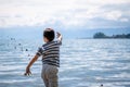 Child playing sands head down on the beach. One little Asian boy in casual clothing beside water in Switzerland Royalty Free Stock Photo