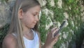 Child Playing Smartphone by Stone Wall in Yard, Girl Uses Tablet, Kid Outdoor Royalty Free Stock Photo