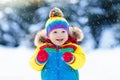 Child playing with snow in winter. Kids outdoors. Royalty Free Stock Photo