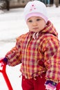 Child playing with spade in snow