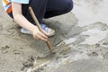 A child playing with a stick in the mud.