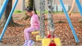 A child playing on a swing at the children\'s playground.
