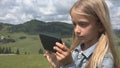 Child Playing Tablet Outdoor in Park, Kid use Smartphone on Meadow Girl in Grass Royalty Free Stock Photo