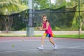 Child playing tennis on outdoor court Royalty Free Stock Photo