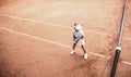 Child playing tennis on outdoor clay court. Top view of little tennis player on open tennis court. Full length shot of sporty Royalty Free Stock Photo