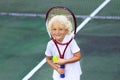 Child playing tennis on outdoor court Royalty Free Stock Photo