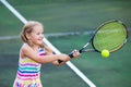 Child playing tennis on outdoor court