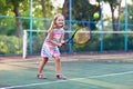 Child playing tennis on outdoor court Royalty Free Stock Photo