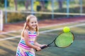 Child playing tennis on outdoor court Royalty Free Stock Photo