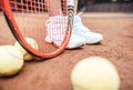 Child playing tennis on outdoor court. Cropped image of child legs on tennis court. Closeup of tennis ball, racket and shoes. Royalty Free Stock Photo