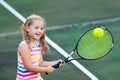 Child playing tennis on outdoor court Royalty Free Stock Photo