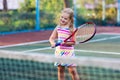 Child playing tennis on outdoor court Royalty Free Stock Photo