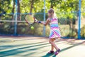 Child playing tennis on outdoor court Royalty Free Stock Photo