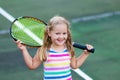 Child playing tennis on outdoor court Royalty Free Stock Photo