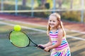 Child playing tennis on outdoor court Royalty Free Stock Photo