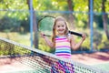 Child playing tennis on outdoor court Royalty Free Stock Photo