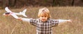 Child playing with toy airplane. Happy child playing. Little boy with plane. Little kid dreams of being a pilot