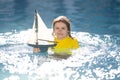 Child playing with a toy boat. Little kid boy sailing toy ship on sea water. Summer vacation with kids. Kid dreaming Royalty Free Stock Photo