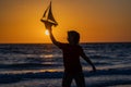 Child playing with a toy boat. Little kid boy sailing toy ship on sea water. Summer vacation with kids. Kid dreaming Royalty Free Stock Photo