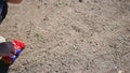 A child is playing with a toy car on the sand