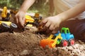 CHILD PLAYING WITH TOY DIGGER TRUCK IN DIRT Royalty Free Stock Photo