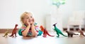 Child playing with toy dinosaurs. Kids toys