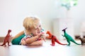 Child playing with toy dinosaurs. Kids toys