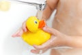 Child playing with toy rubber duck in bath with soap foam. Royalty Free Stock Photo