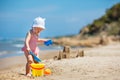 Child playing on tropical beach. Little girl digging sand and build a sand castle at sea shore. Kids play with sand toys. Travel Royalty Free Stock Photo