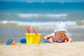 Child playing on tropical beach. Little girl digging sand at sea shore. Kids play with sand toys. Travel with young children Royalty Free Stock Photo